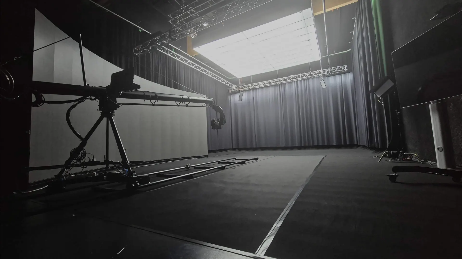 Spacious empty studio with dark curtains and a top light